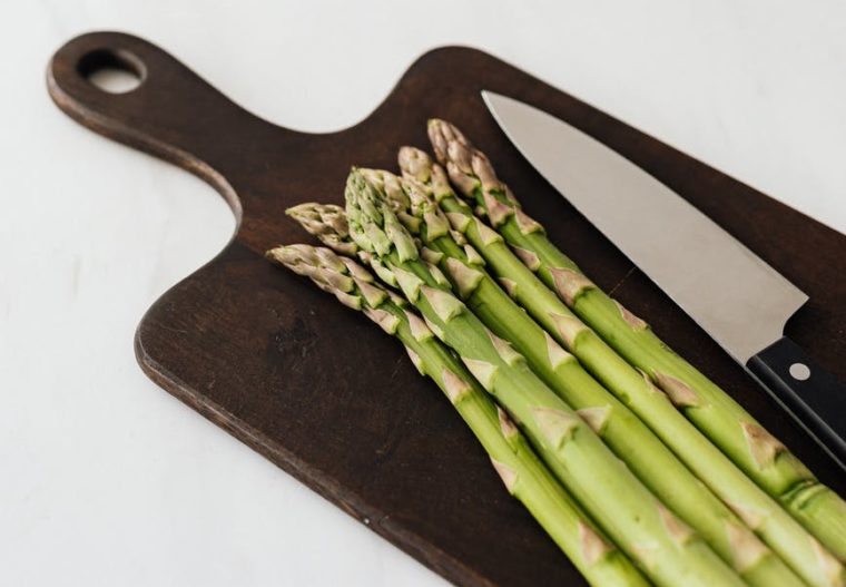 asparagus on cutting board on white table